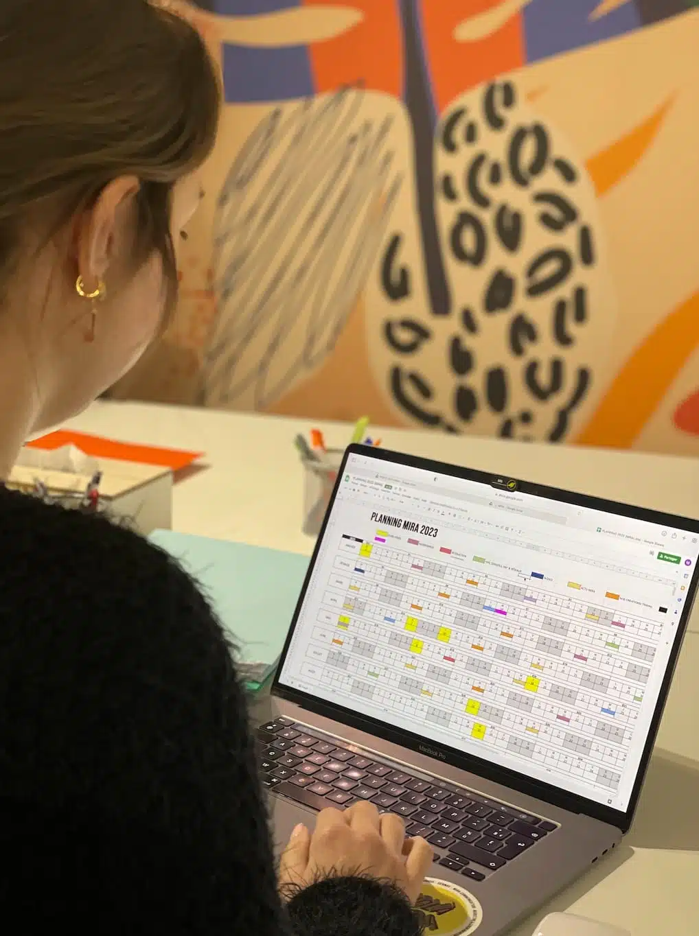 Photographie community manager devant pc planning 2023