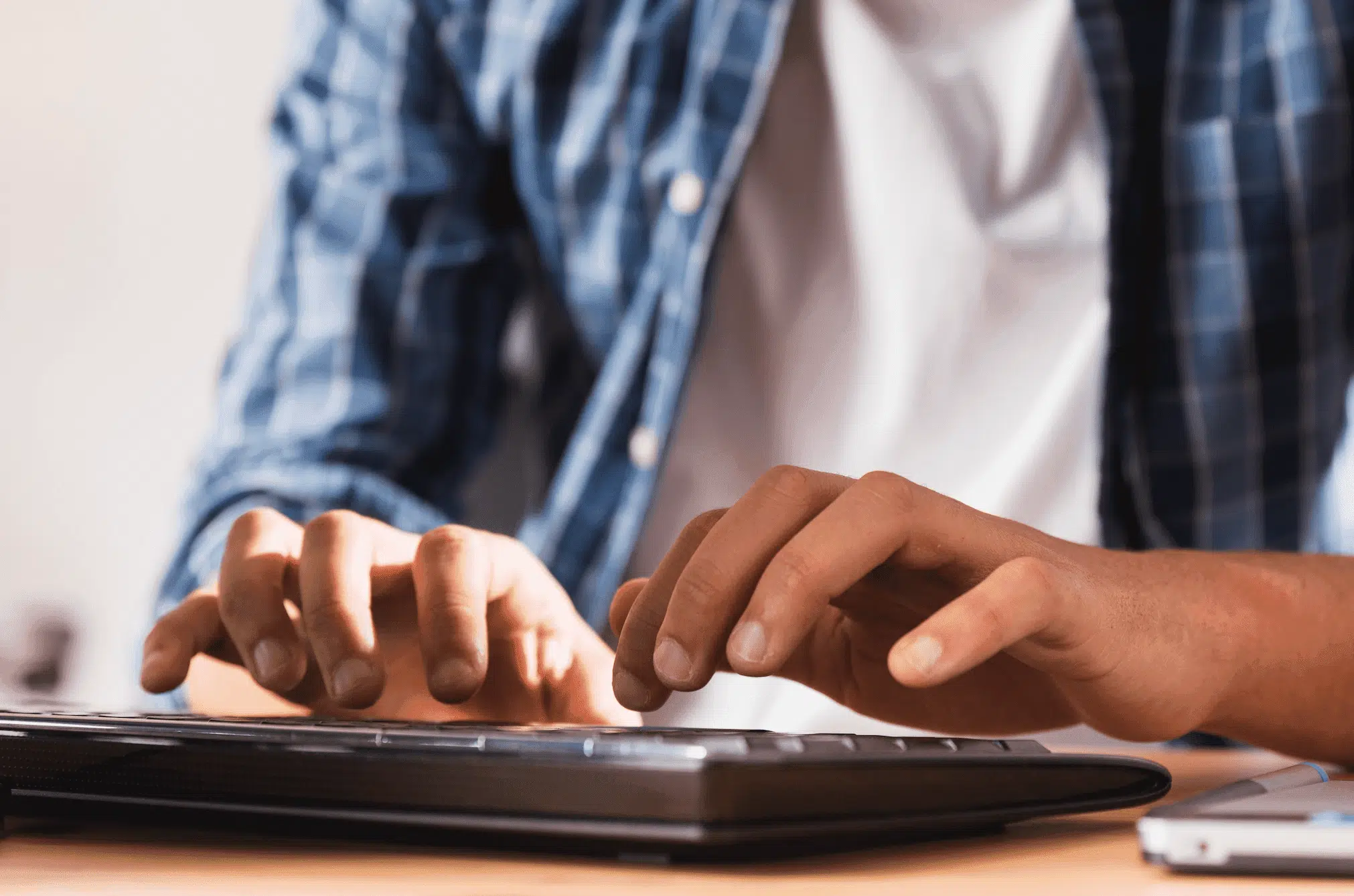 Homme en train de taper un mot sur son clavier d'ordinateur